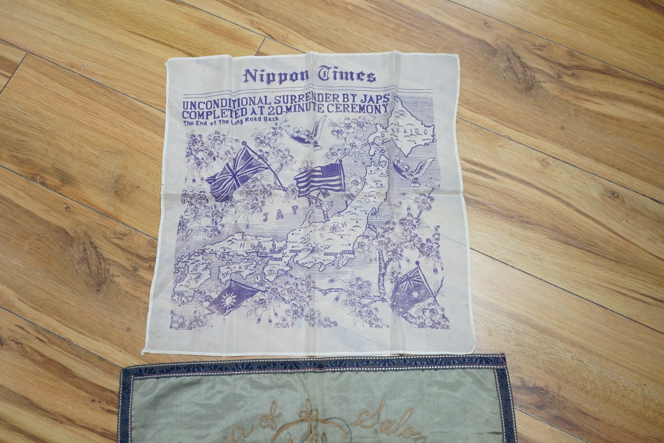 A WWII silk printed handkerchief; ‘Nippon Times’ commemorating the surrender of the Japanese, together with a WWI Army Service Corps emblem dated 1918, 44 x 45cm